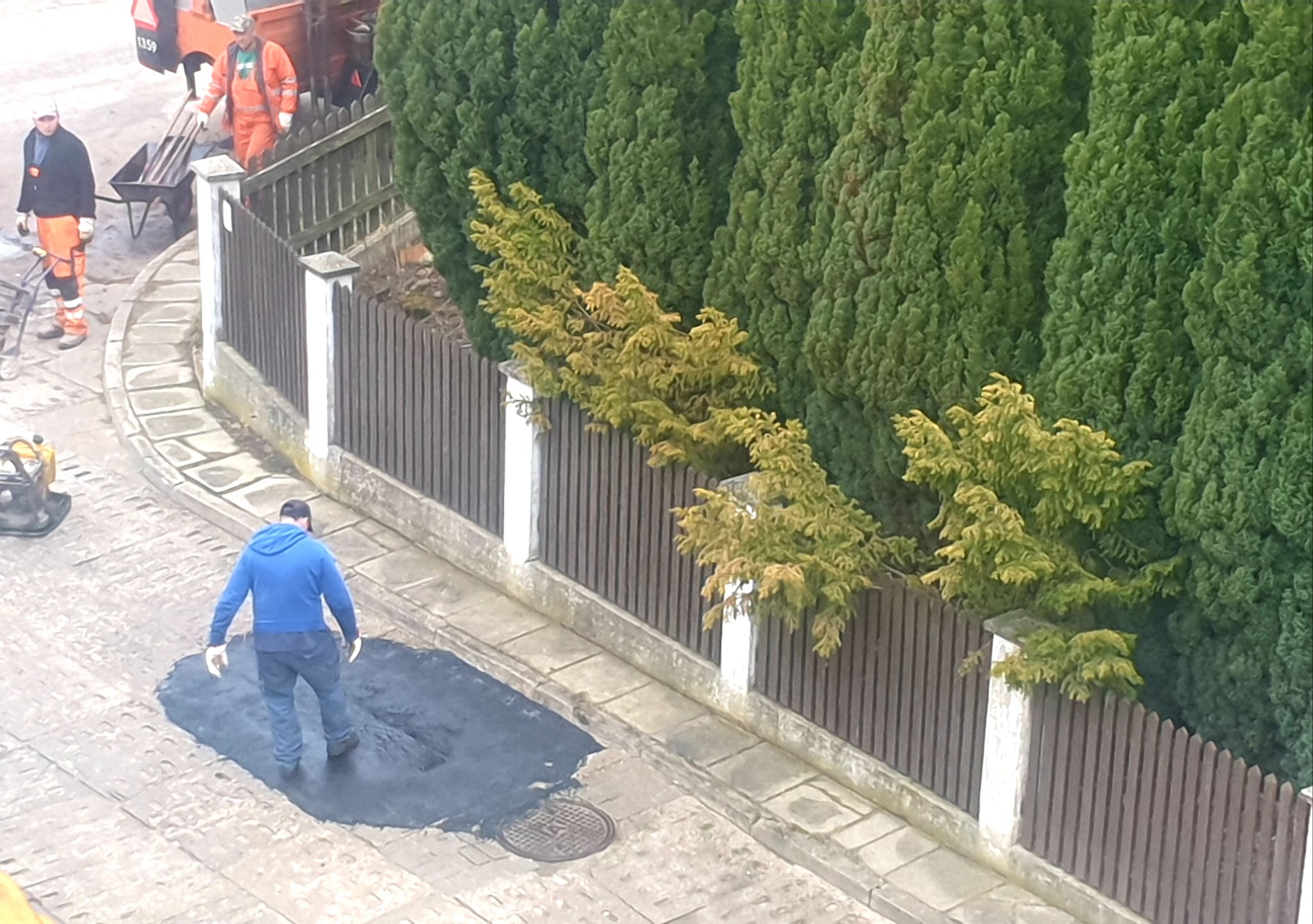 Zdjęcie z remontu po gdyńsku w Gdyni Dąbrowie. Mężczyzna przyklepuje dziurę nogą.